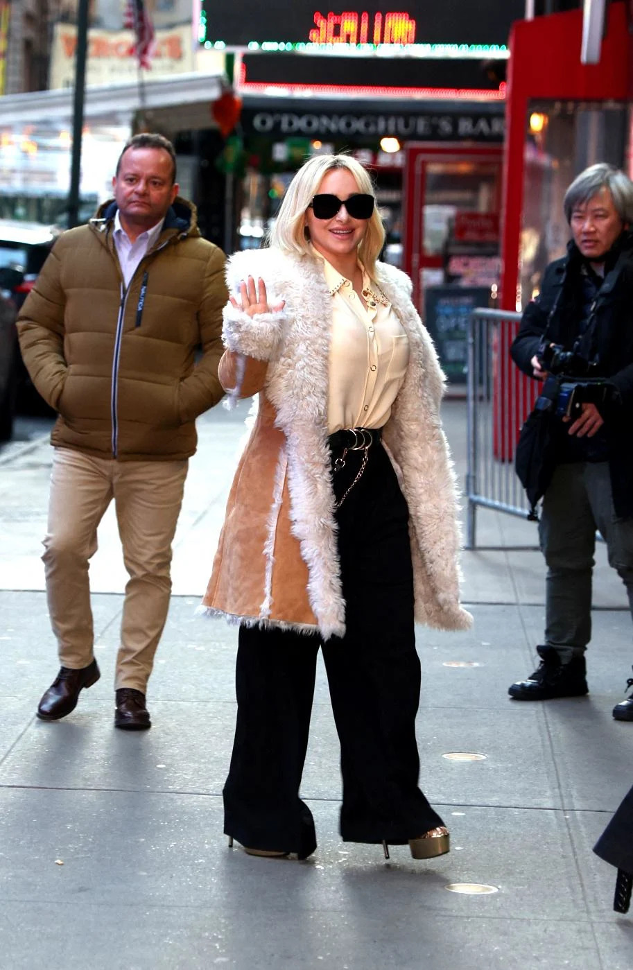 Hayden Panettiere usando casaco claro e óculos escuros em uma aparição pública