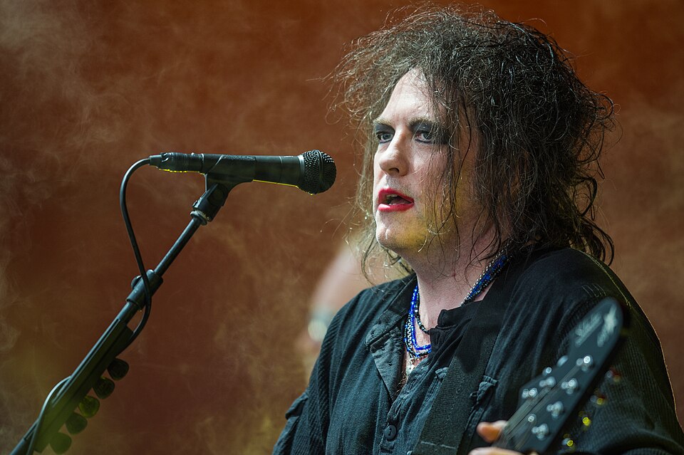Robert Smith, do The Cure, cantando e tocando guitarra no Roskilde Festival em 2012