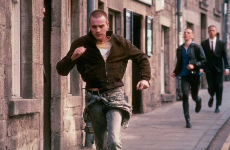 Mark Renton, interpretado por Ewan McGregor, corre por uma rua em uma cena de Trainspotting.