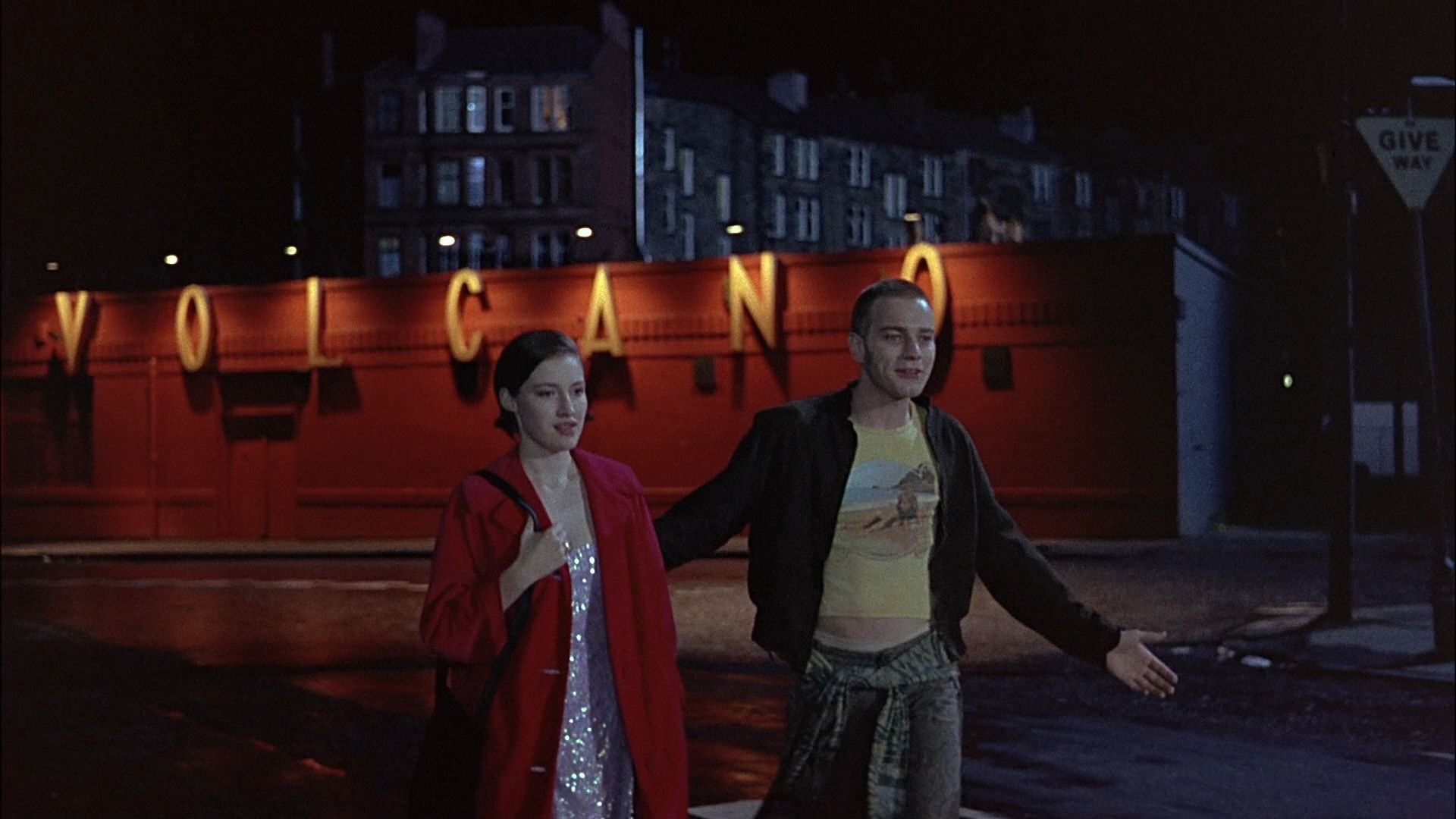 Renton e Diane do lado de fora da boate Volcano em uma cena noturna de Trainspotting.