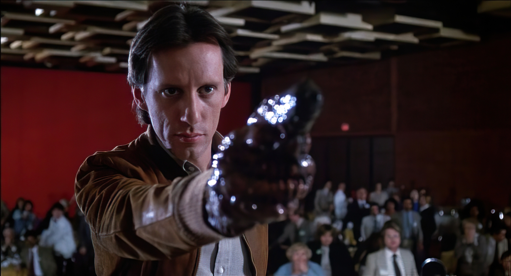 James Woods como Max Renn segurando a arma orgânica de Videodrome